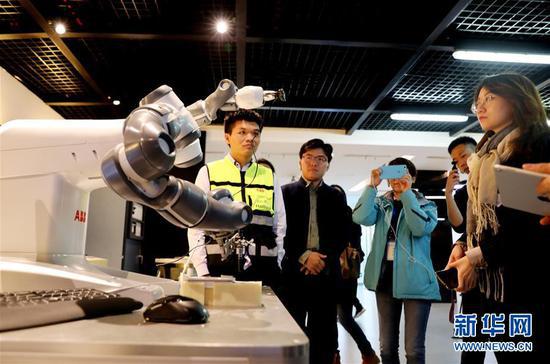 参观者在位于上海浦东新区的ABB集团展示厅观看机器人作业演示（4月10日摄）。新华社记者 方喆 摄