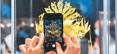 在海南省海口市举办的第二届中国国际消费品博览会上，一件国产黄金头饰吸引观众拍照分享。新华社记者 杨冠宇摄