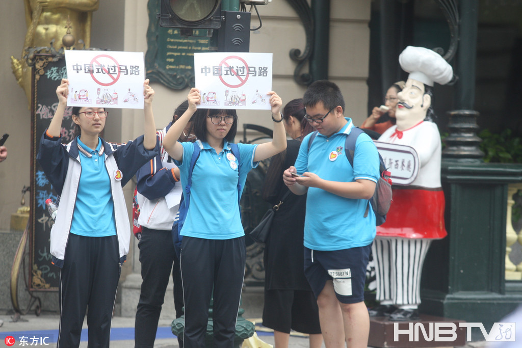 哈尔滨志愿者街头高举提示牌 阻止“中国式过马路” 